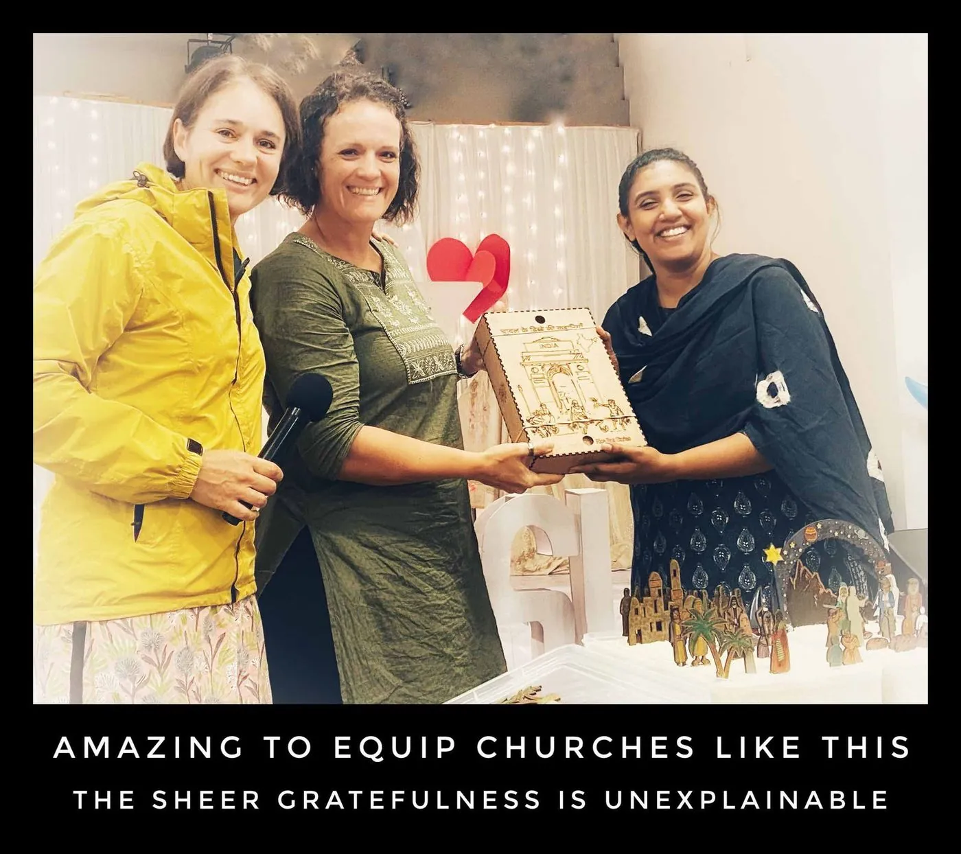 Three women hold up a wooden box of figures, captioned Amazing to equip churches like this, the sheer gratefulness is unexplainable.