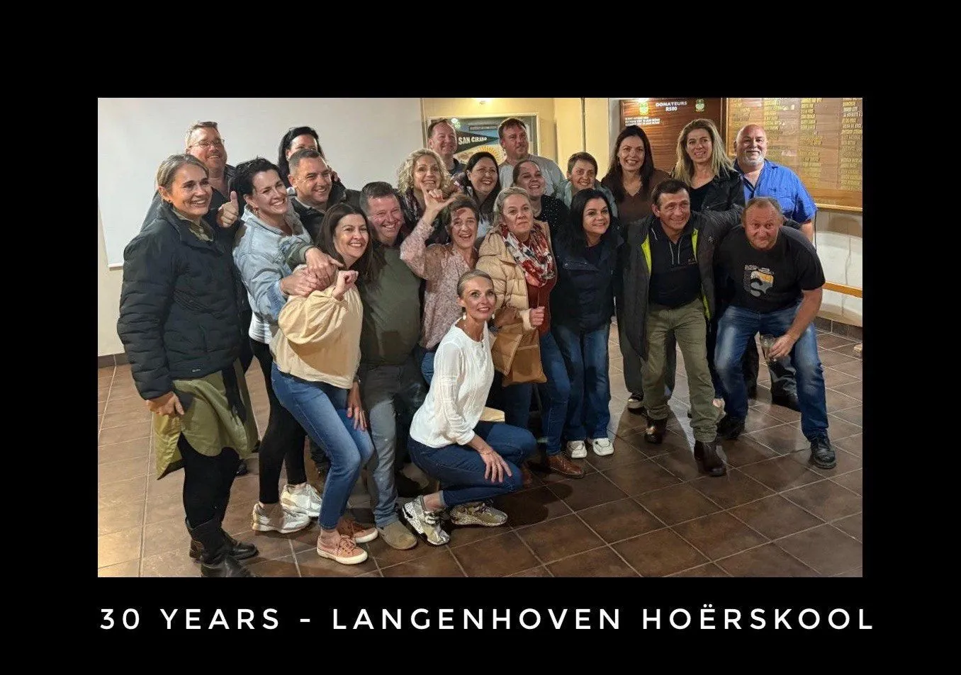 A large group posing together indoors, captioned 30 years, Langenhoven Hoerskool.