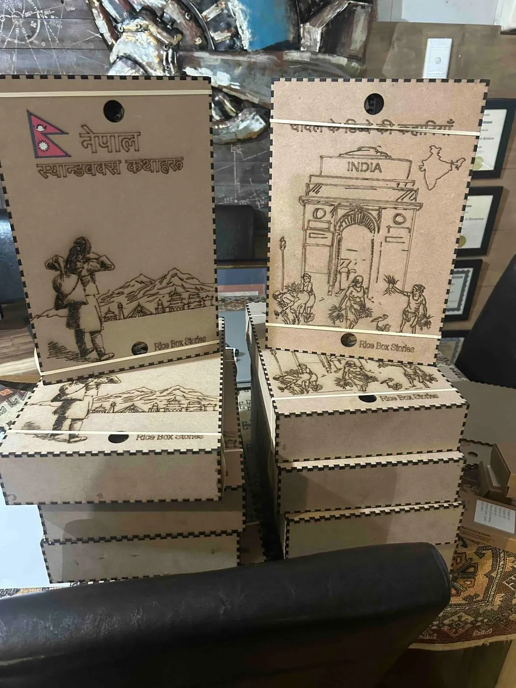 Stacks of engraved wooden tags with drawn landmarks and figures, on a shelf.